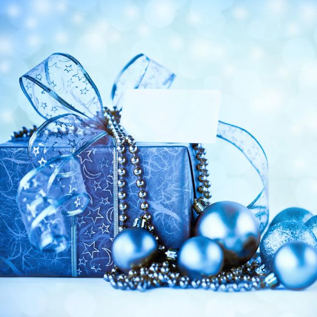 A Christmas present wrapped in blue paper with blue ornaments