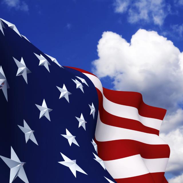 Closeup of an American flag with a blue sky background
