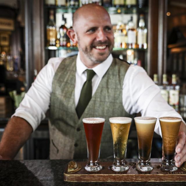 bartender with a beer flight at Raglan Road Irish Pub & Restaurant