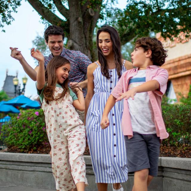 A family dancing in a theme park.