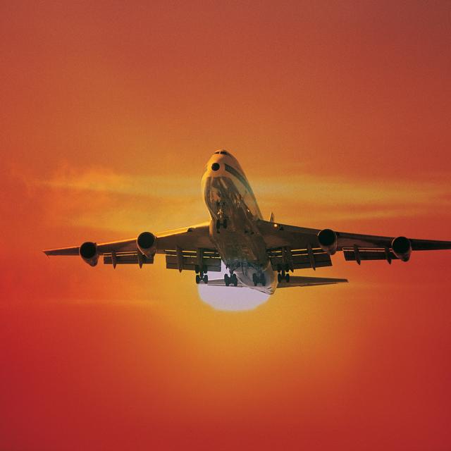 Airplane flying at sunset