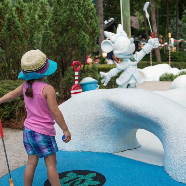 A little girl golfing at Disney's Winter Summerland Miniature Golf