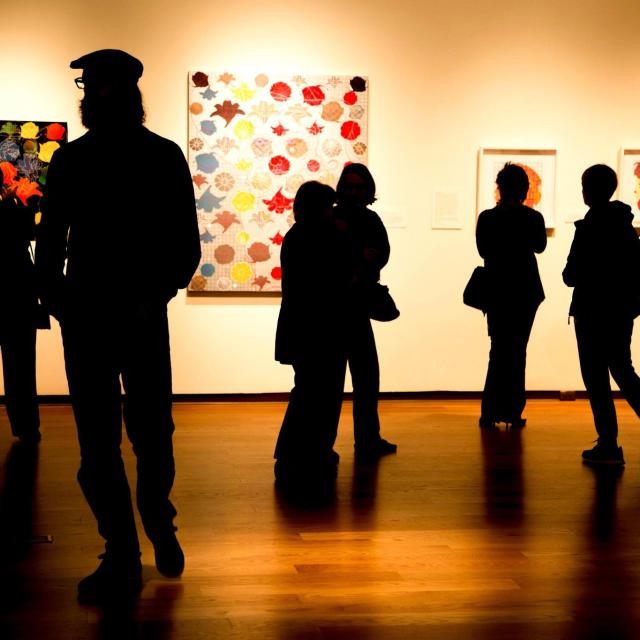 Silhouettes of guests viewing an exhibit at Orlando Museum of Art.