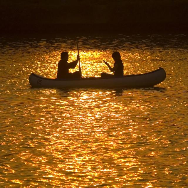 Two people in a canoe at sunset