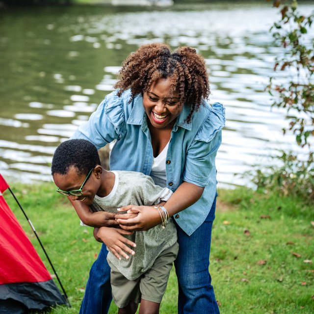 Mother and son having fun and laughing at their campsite