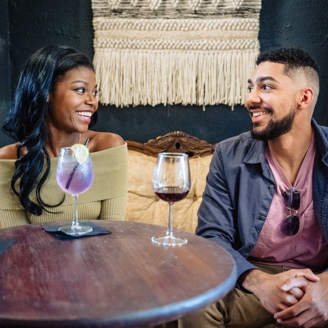 Couple smiling and enjoying each other's company while drinking a glass of wine