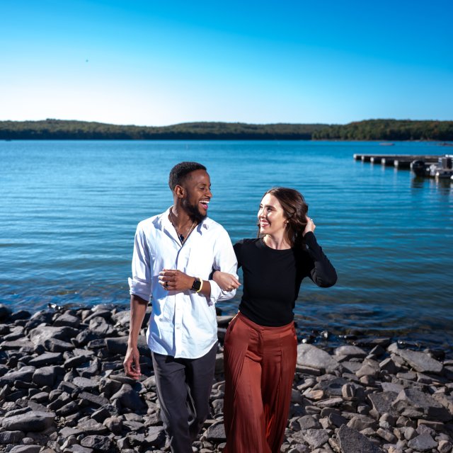 A couple smiling and enjoying some time at the lake.