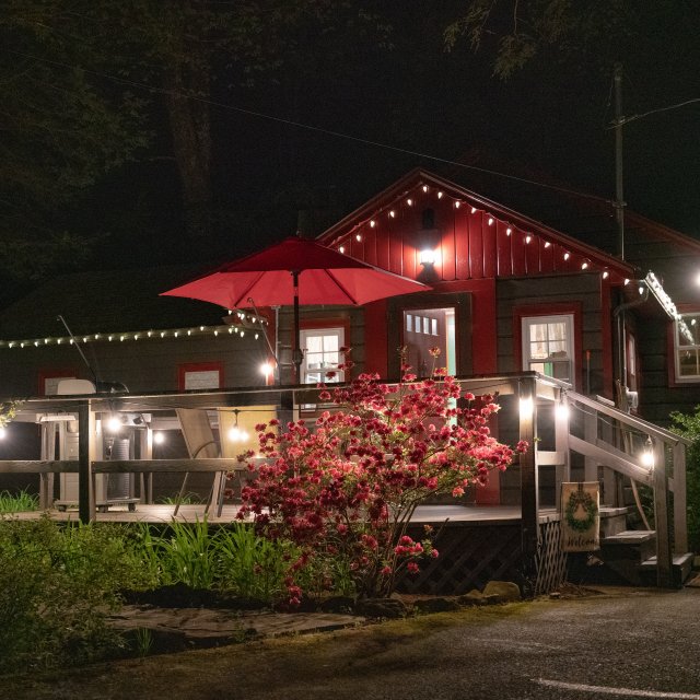 Exterior of a cabin at night with lights shining