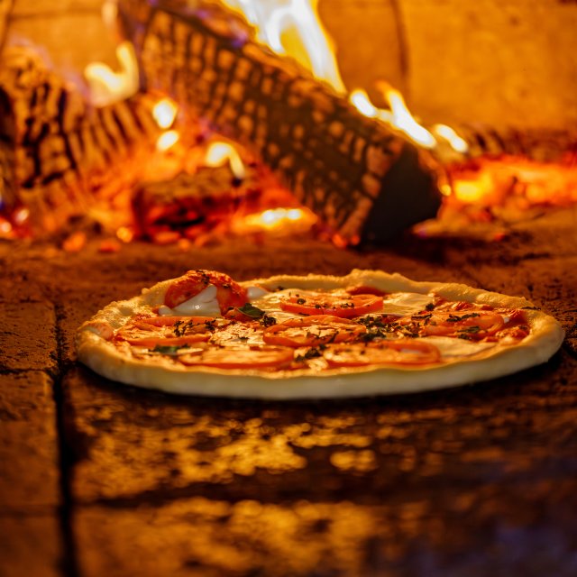 A delicious pizza that just came out of a brick overn.