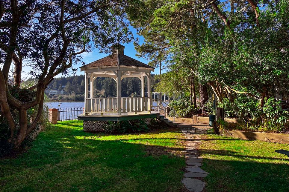 A classic white gazebo in a small park on the edge of the river.