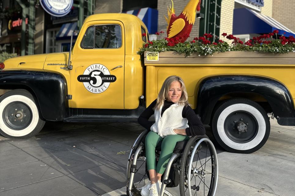 Kristin in front of the yellow logo truck at the Market.