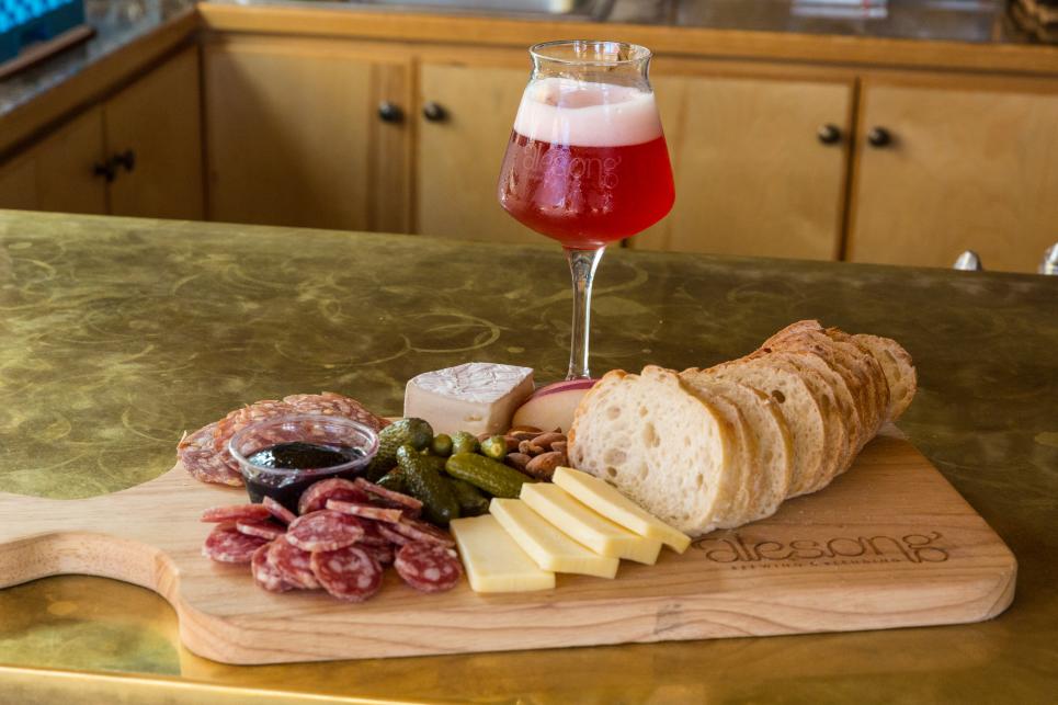 Alesong Brewing & Blending Glass of Beer with Bread and Cheese Plate.
