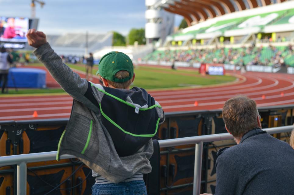 A young kid cheers for a race at Hayward Field