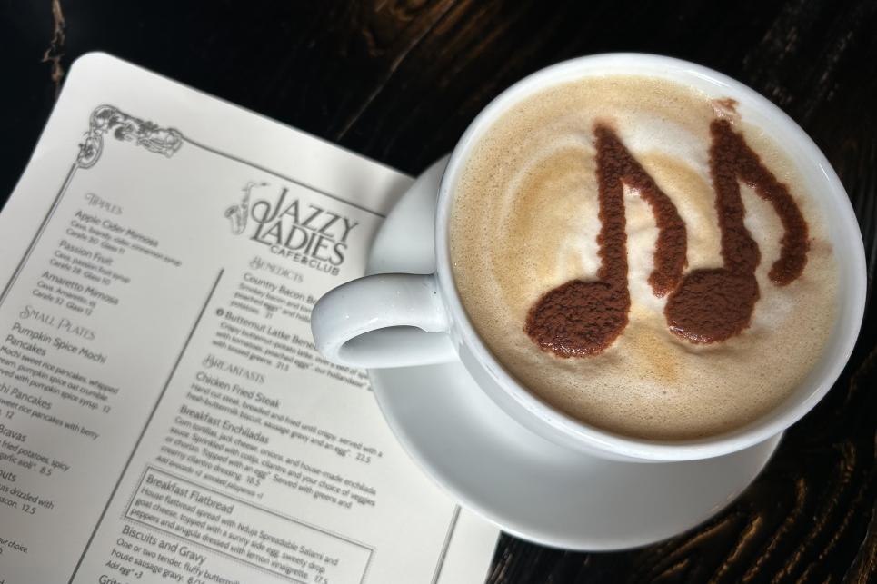 A cup of coffee with music notes in the foam.