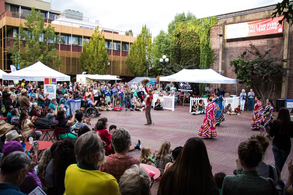 A crowd gathers around folkorico dancers in Kesey's open-air square