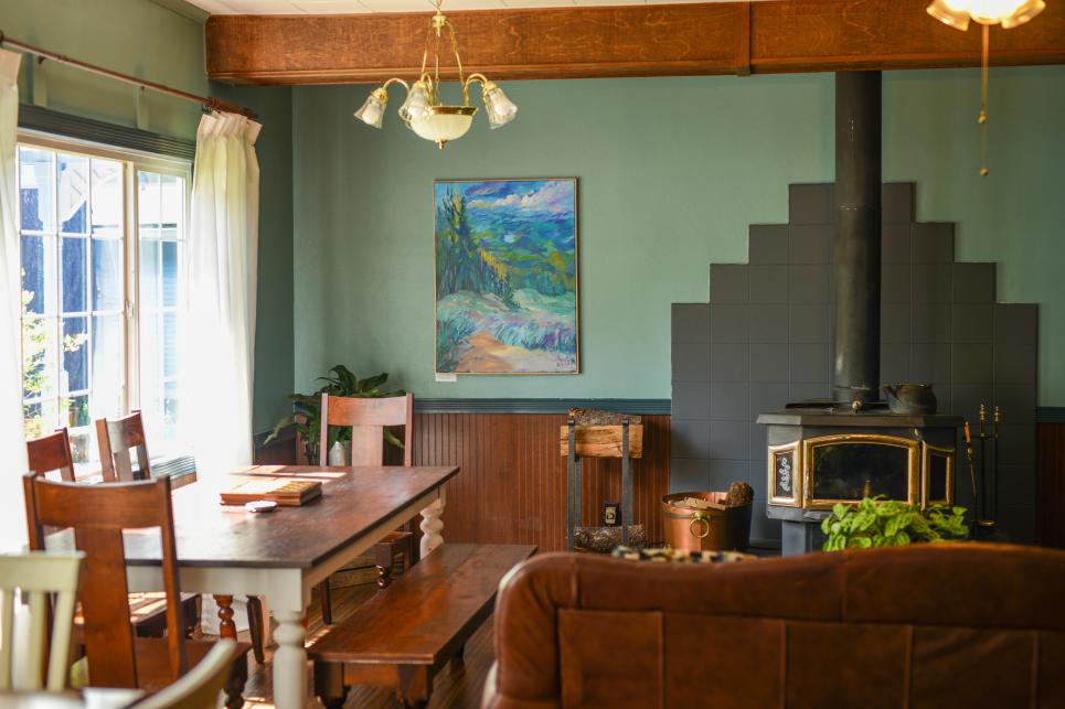 The common room at a mountain B&B with a table for games and a fireplace.