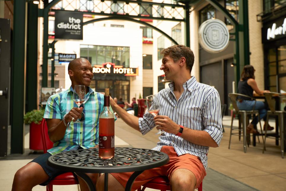A couple sits at a table with a glass of wine in Market Alley.