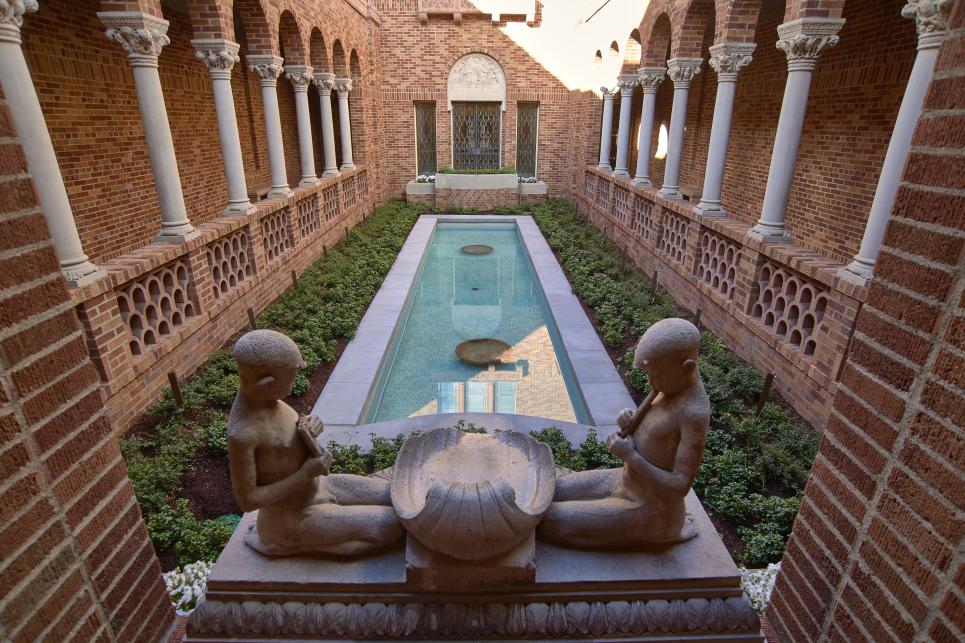 Stone statues above a pool of water in the courtyard.