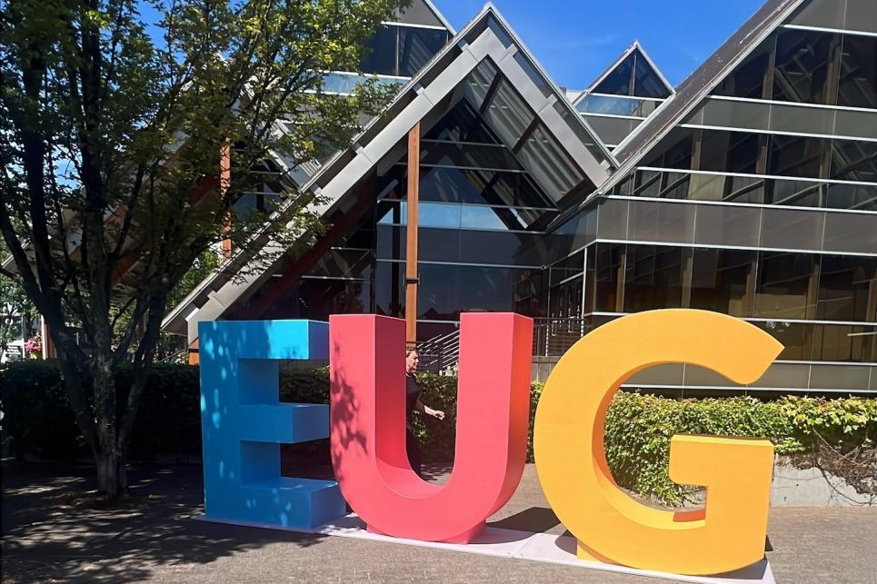 A large blue "E", red "U" and yellow "G" stand in front of the Hult Center.