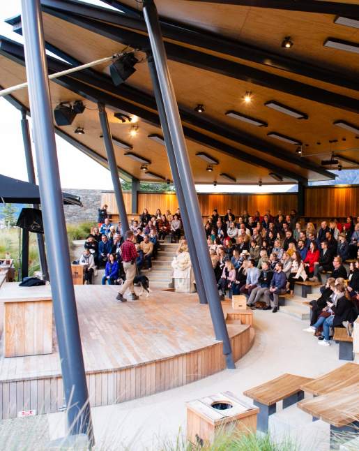 Conference group sitting in an auditorium listening to a man speak