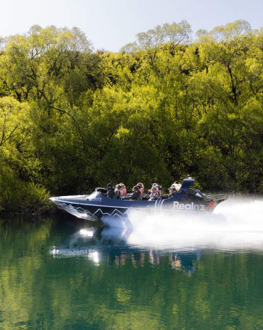 Jet boat speeding across a glassy lake