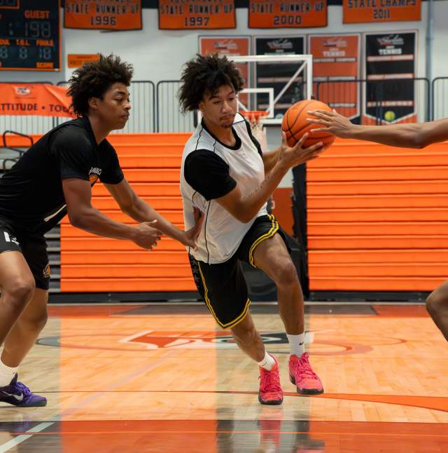 Three athletes playing a game of basketball during the Moneyball Shoutout event