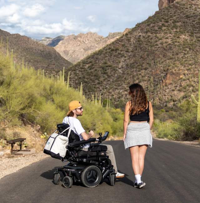 woman standing next to a man in a wheelchair in the desert at Sabino Canyon Tucson