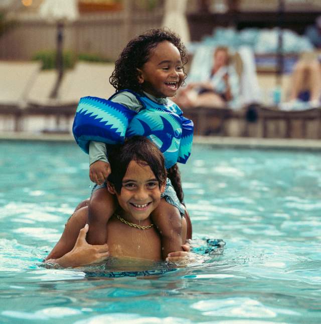 Two children playing in the resort swimming pool