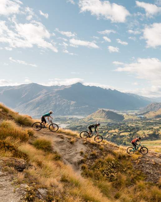 Three mountain bikers on Pack Track and Sack Trail, Coronet Peak