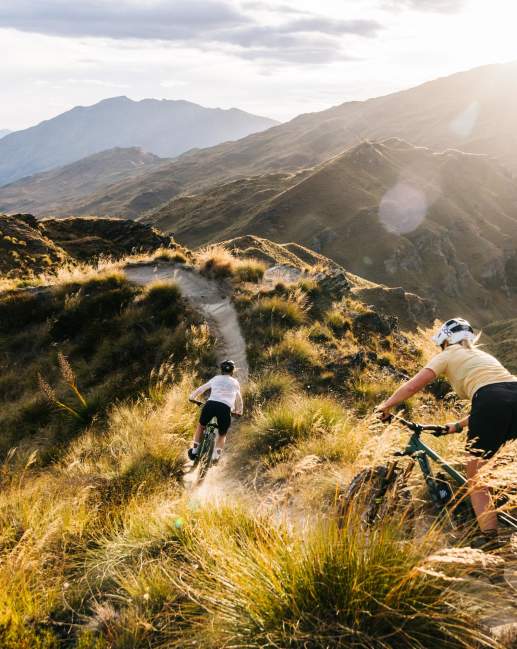 Two people riding mountain bikes through the mountains
