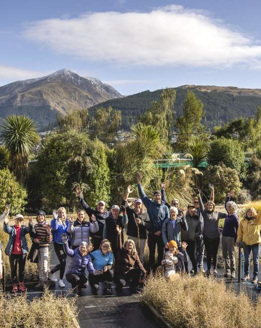 Group of people planting trees with view of mountains in background