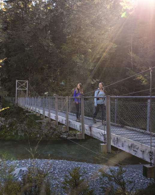 Two female hikers on the Routeburn Track swing bridge