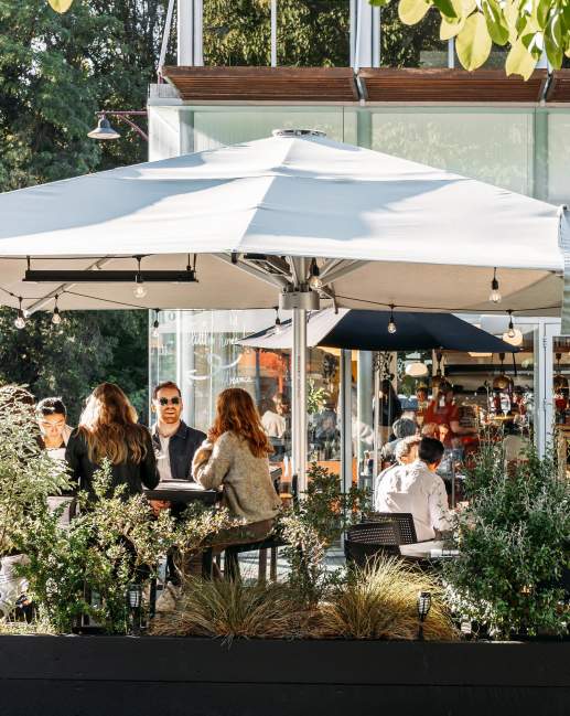 View of a people sitting in a cafe courtyard surrounded with greenery