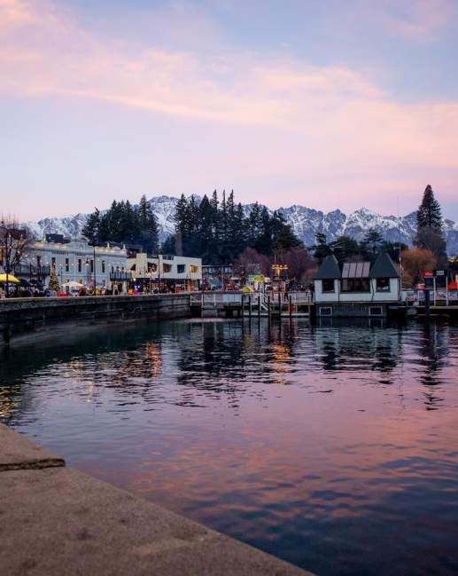 Queenstown waterfront in winter at sunset with the Remarkables mountain range covered in snow