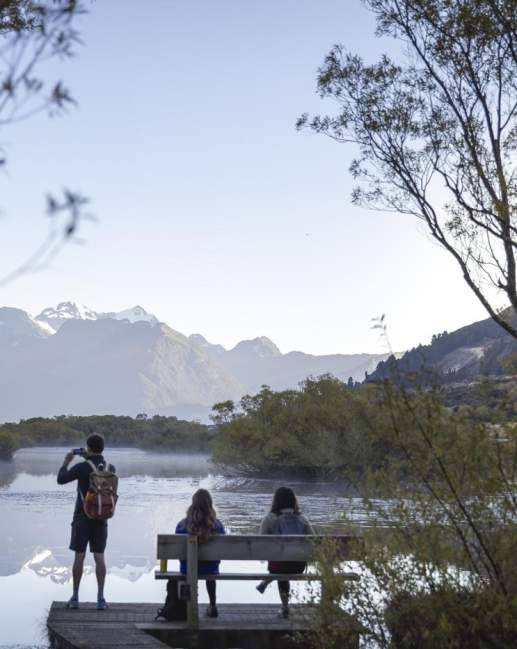 People at the Glenorchy Lagoon Walkway lookout, overlooking lake and mountains