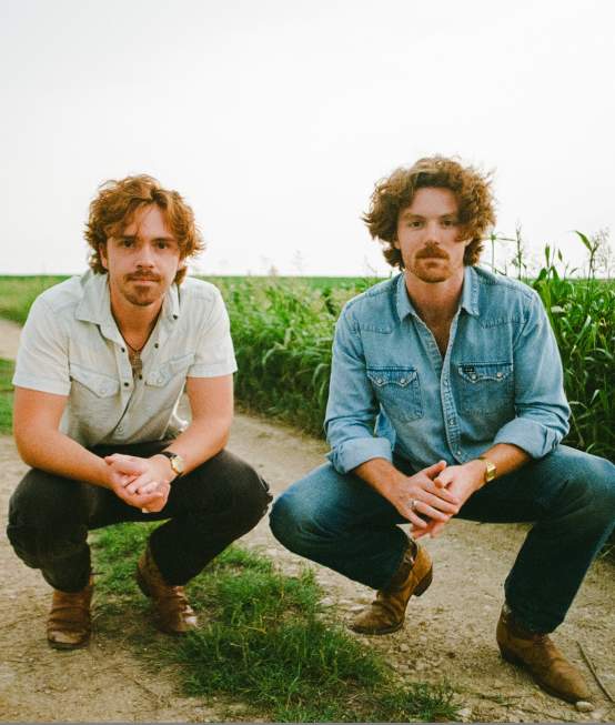 Briscoe band members crouch on a dirt road