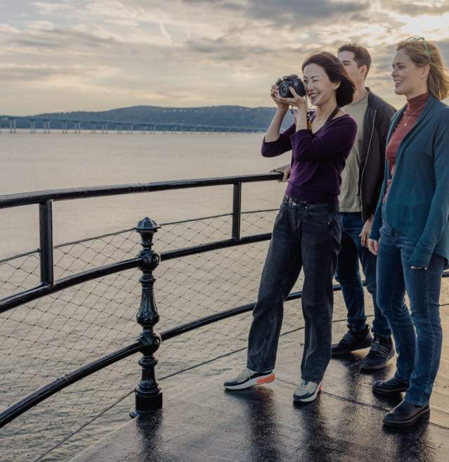 A woman takes a picture of the Tarrytown waterfront.
