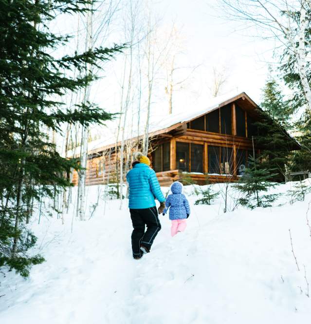 Winter cabin with family outside on Gunflint Trail