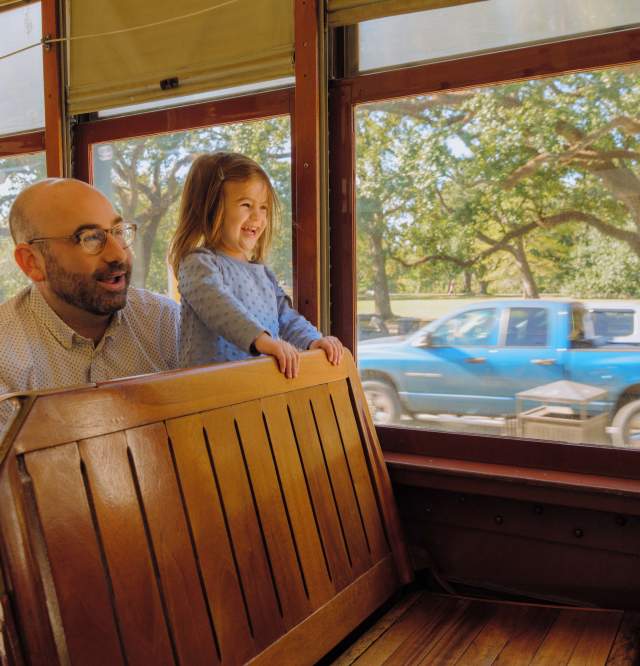 A father and daughter enjoying the St. Charles Avenue Streetcar together