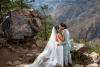 Bride and Groom embracing on a boulder lookout with majestic Clear Creek Canyon and Rocky Mountains in background
