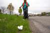 Woman picking up trash along the highway