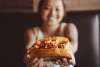 a very happy girl holding up a lobster roll at Rockfish Public House