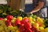 Women buying red and yellow peppers