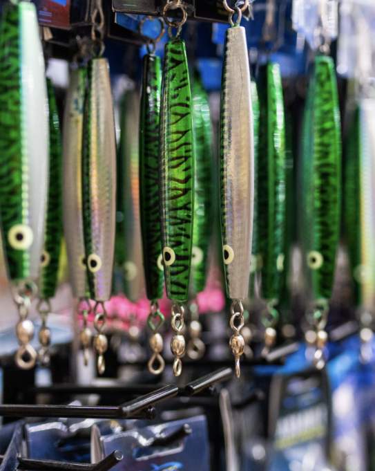 Green fishing lures hang on a shop wall