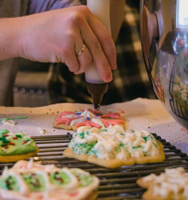 A person decorating holiday cookies.