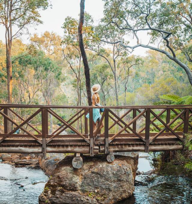 Girls walks across a bridge at Araluen Botanic Park in Armadale