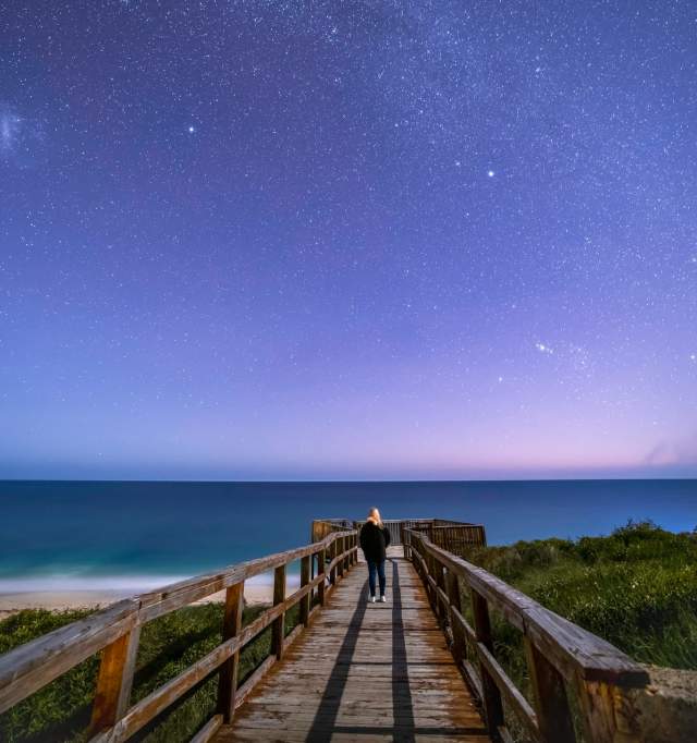 Girl at end of jetty with night sky in Guilderton