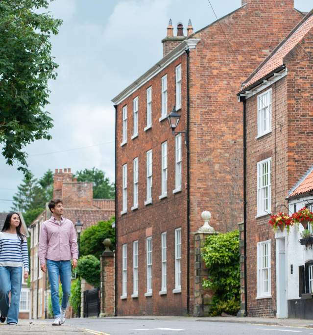 Two people walking along the street in Louth with a traditional country pub in the background