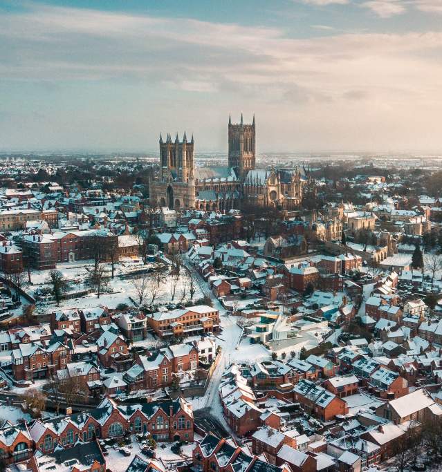 An aerial shot of Lincoln covered in snow, with Lincoln Cathedral in the distance