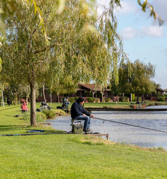 A man sat by a lake fishing